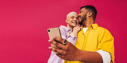 Happy gay couple taking a selfie together