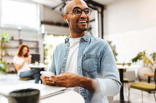 Digital nomad working with a smartphone at a cafe