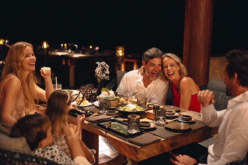 Family enjoying a celebratory dinner at a cozy gourmet restaurant