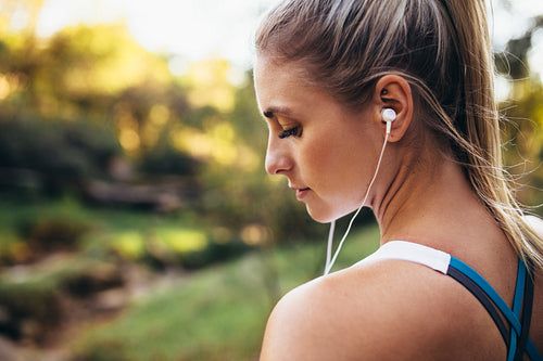 Woman runner wearing earphones during workout