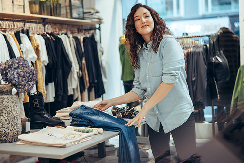 Clothing store owner setting up display