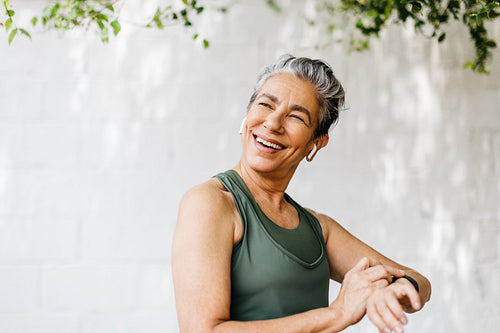 Staying active with technology, happy elderly woman tracking her fitness with a smartwatch outdoors