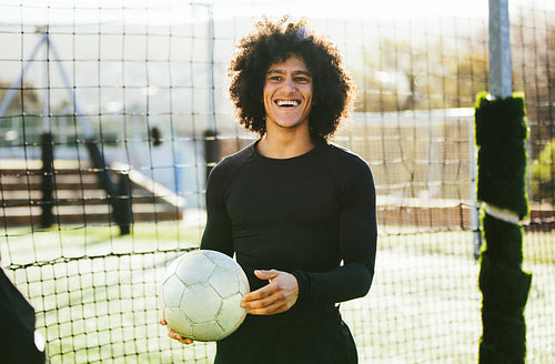 Teenage football player laughing on field