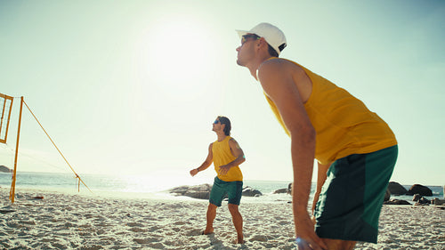 Handheld action shot of male beach volleyball athletes winning a point