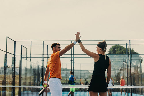 Victorious athletes celebrating championship win in a padel court