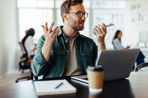 Advertising agent speaking to a client on the phone in an office