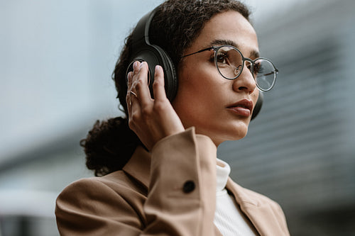 Businesswoman using wireless headphones while commuting