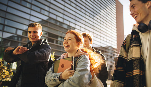 Happy students walking outdoors in college campus