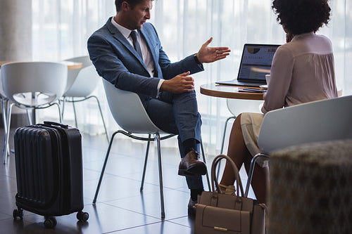 Business people using laptop while waiting for flight