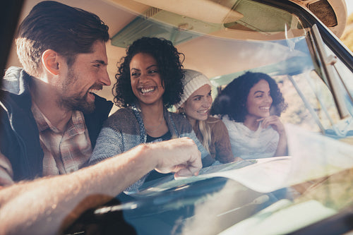 Group of friends travelling in a van with map