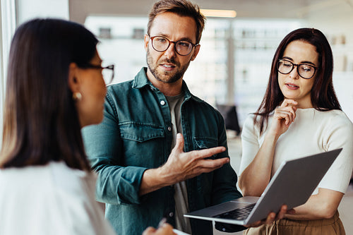 Business people having a discussion and using a laptop