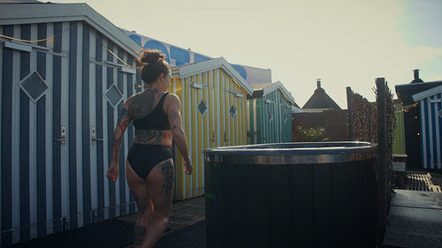 Woman embraces a cold tub ritual for outdoor recovery and wellness