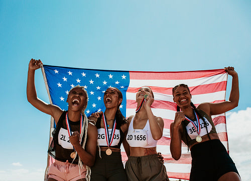 Group of winning US athletes with national flag
