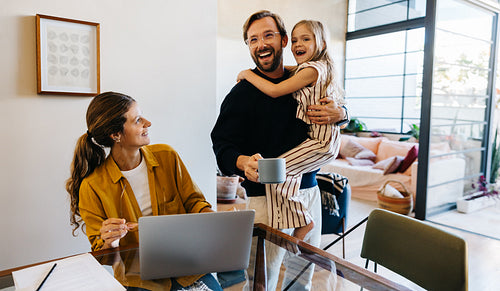 Joyful family at home with laptop and kids