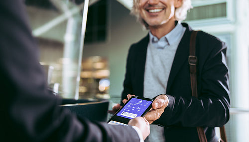 Man showing flight ticket to staff on phone