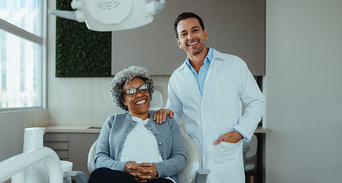 Senior woman and dentist smiling during clinic visit