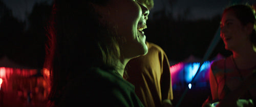 Young woman dancing in the lights of a music festival
