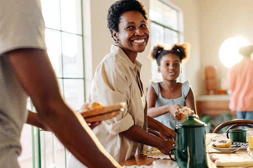 Mom and kids setting the table for a delicious Brazilian breakfast with pão de queijo