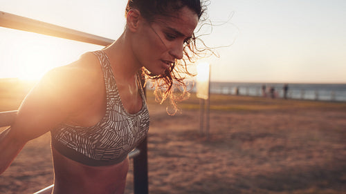 Strong young woman exercising on wall bars