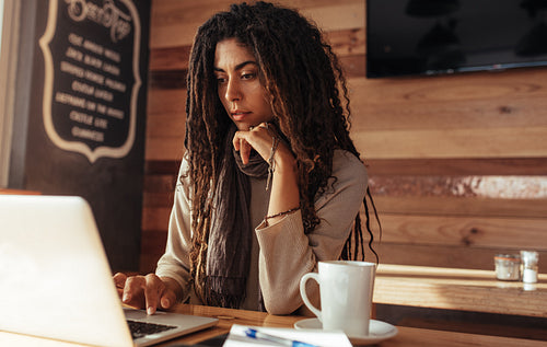 Freelancer woman working on laptop computer in a cafe