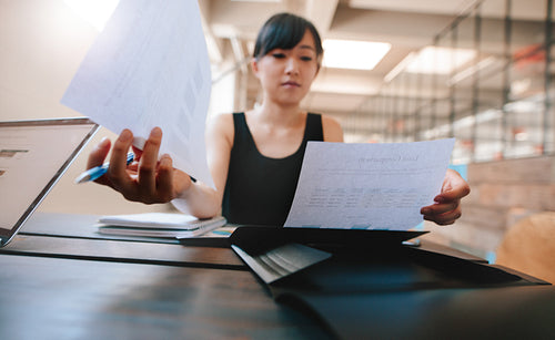 Businesswoman going through documents at her desk