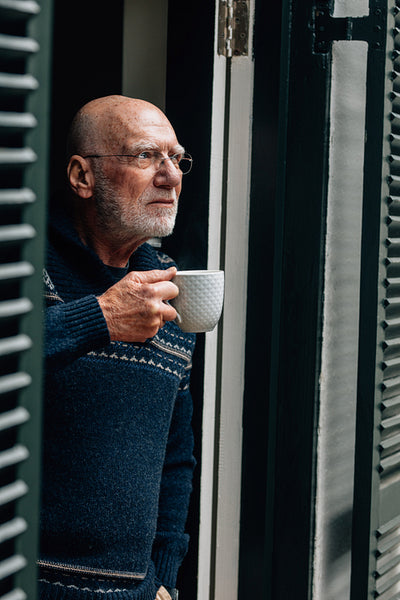 Portrait of a old man holding a coffee cup