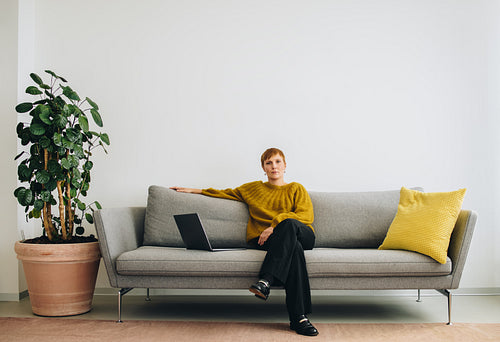 Female executive sitting on sofa in office lobby