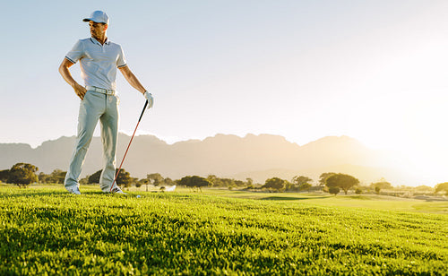 Young man with golf stick on field