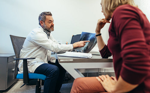 Mature doctor discussing medical scan result with patient