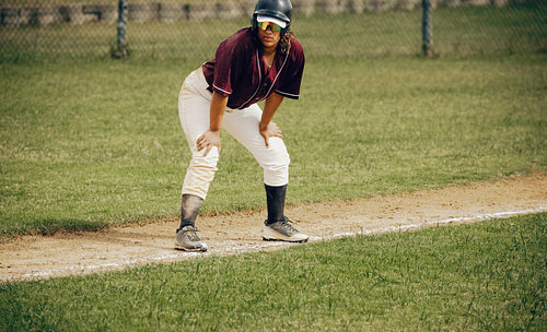 Focused base runner preparing for action on the baseball field during an intense game
