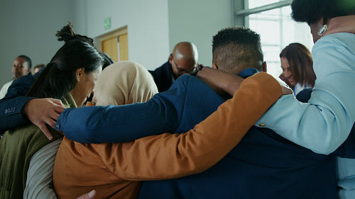 Diverse team collaborating and demonstrating unity in a supportive corporate huddle