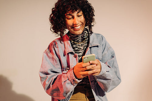 Cheerful young woman sending a text message