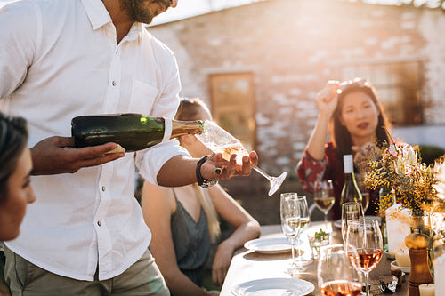 Man serving champagne to friends during party