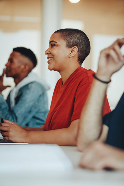 Smiling female student sitting in college classroom