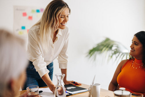 Cheerful businesswoman brainstorming with her team
