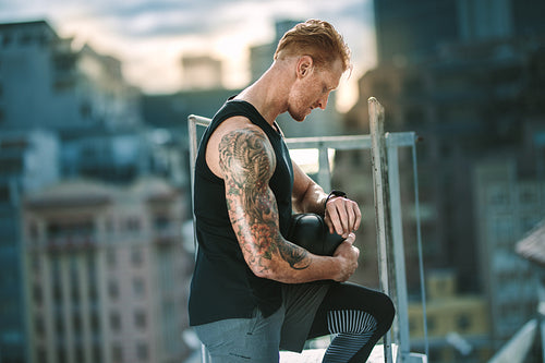 Athlete standing on rooftop looking at the time