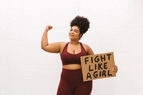 Woman with "Fight like a girl" brown board