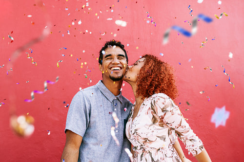 Happy young couple celebrating with confetti all around.