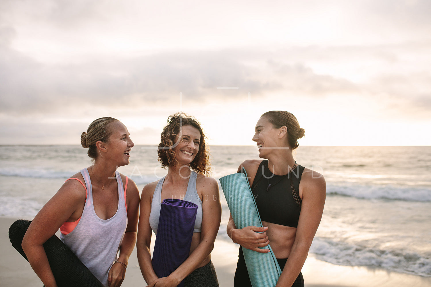 Three women carrying yoga mats standing at the beach – Jacob Lund  Photography Store- premium stock photo