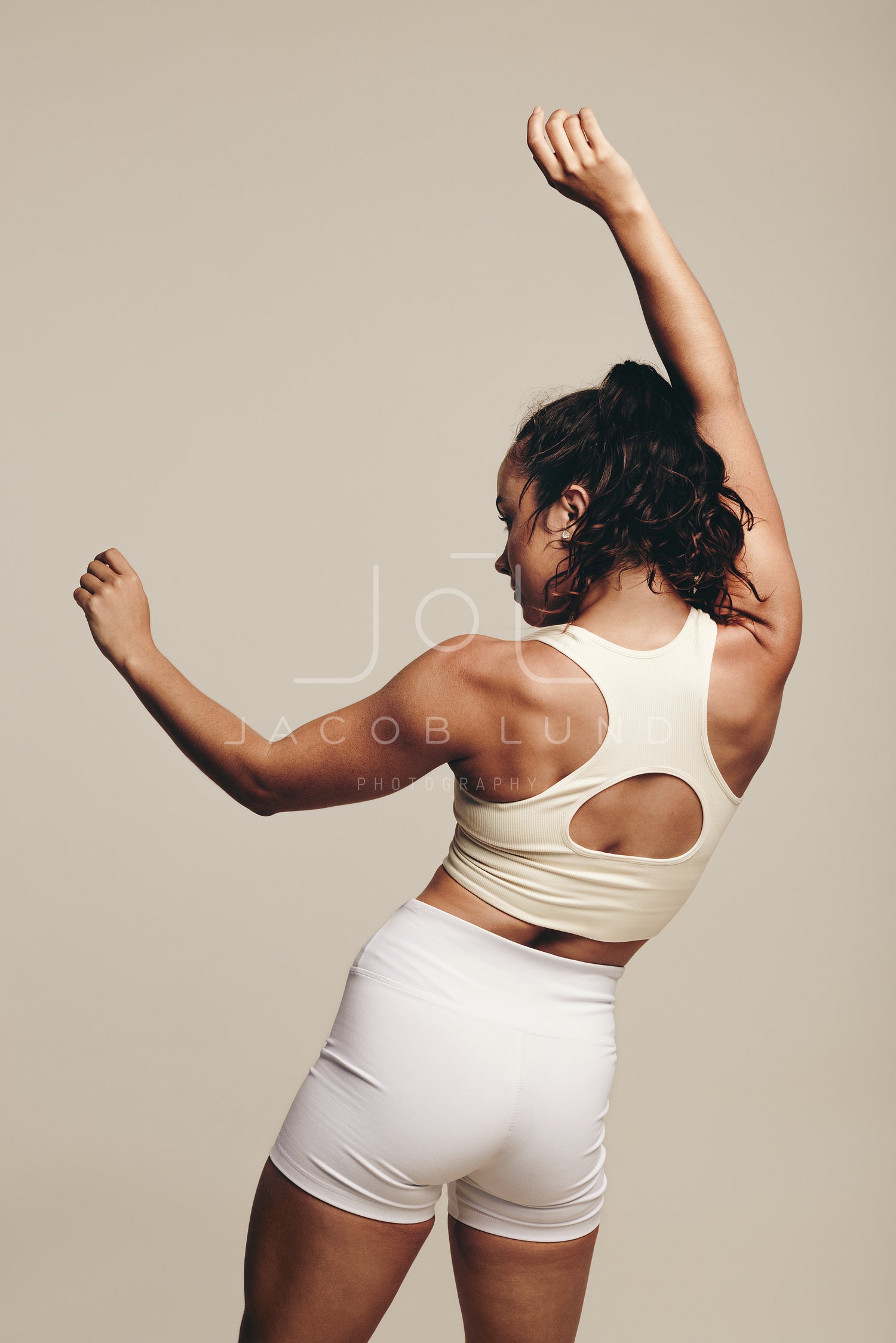 Fotografia do Stock: Sport and women. Rear view of strong fitness athlete,  female bodybuilder, flexing muscles, showing fit body, biceps and athletic  back, smiling satisfied, white background