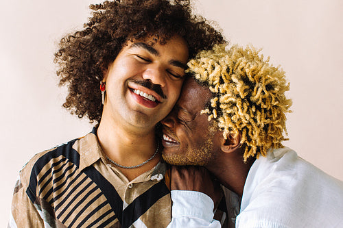 Smiling black man watering a flower pot at home – Jacob Lund