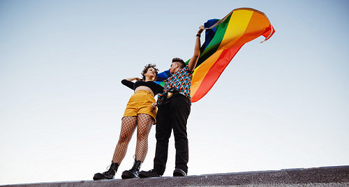 Smiling queer couple standing against a rainbow flag – Jacob Lund  Photography Store- premium stock photo