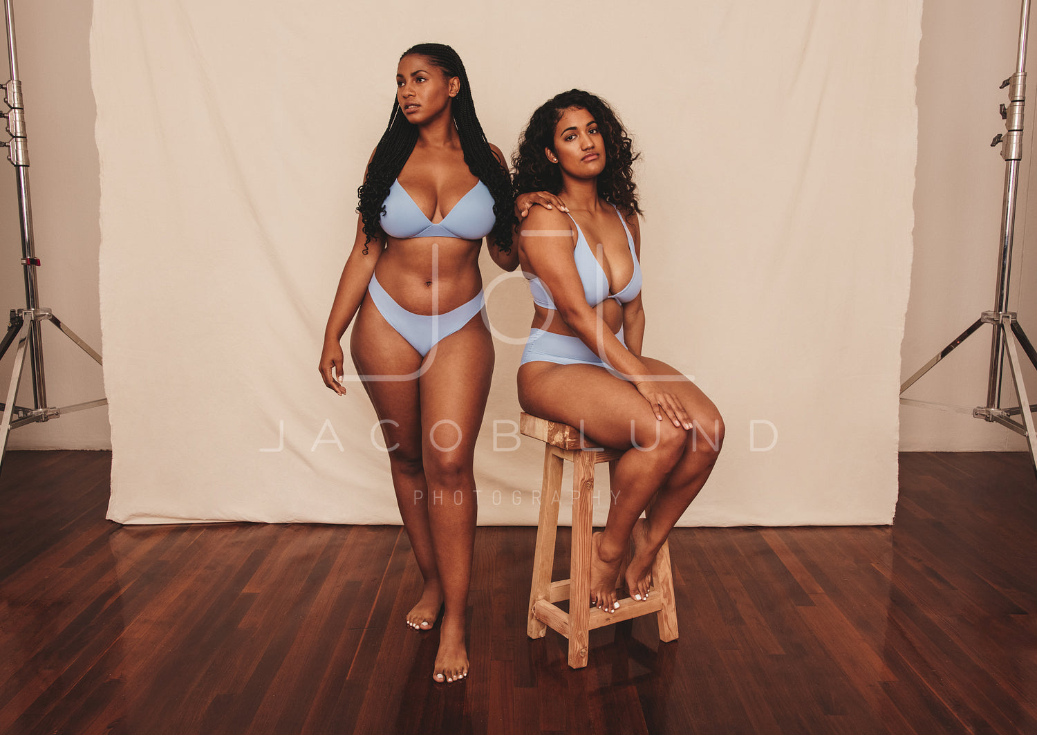 Two female friends standing in blue underwear in a studio – Jacob Lund  Photography Store- premium stock photo