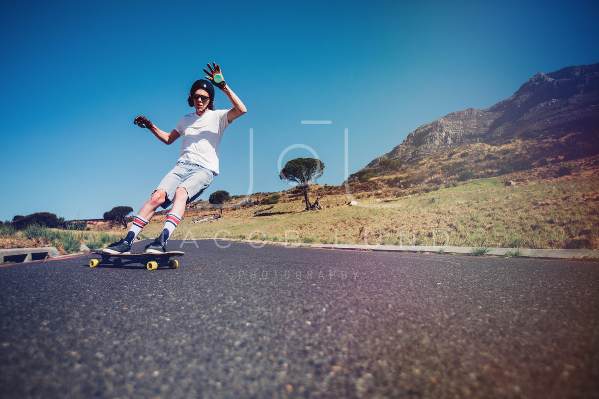Confident man riding longboard across city street - a Royalty Free Stock  Photo from Photocase