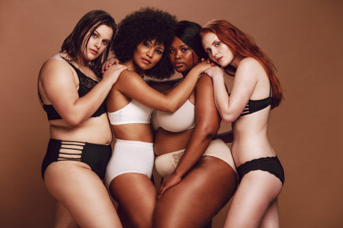 Cropped shot of black female in underwear holding her fat belly