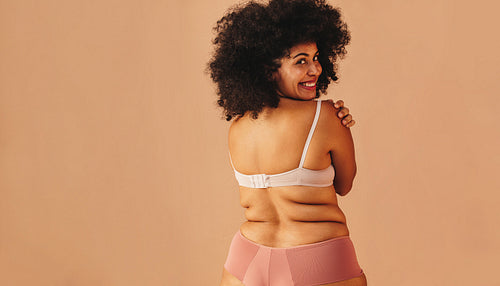 Happy curvy woman wearing underwear in a studio
