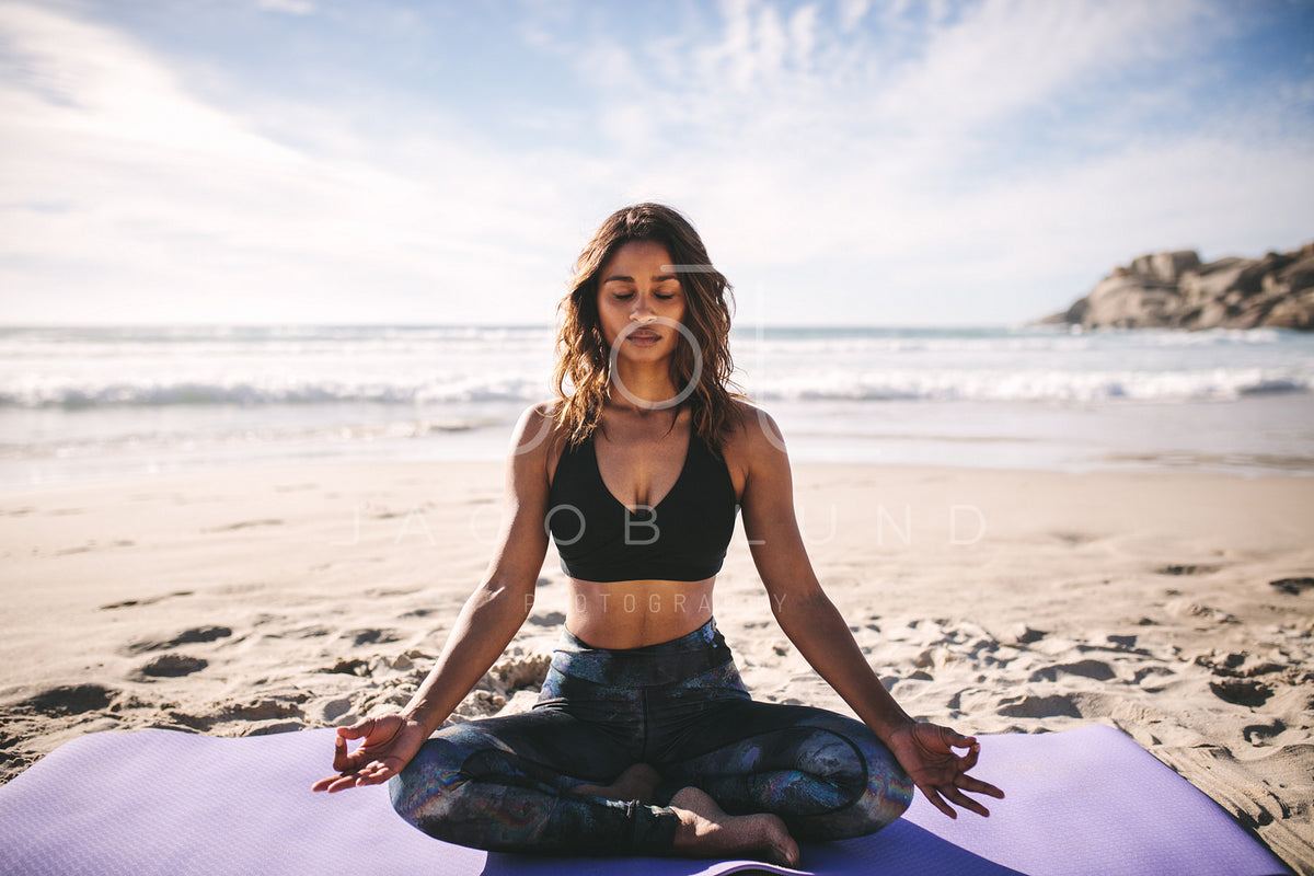 Woman doing yoga asana meditation on the beach
