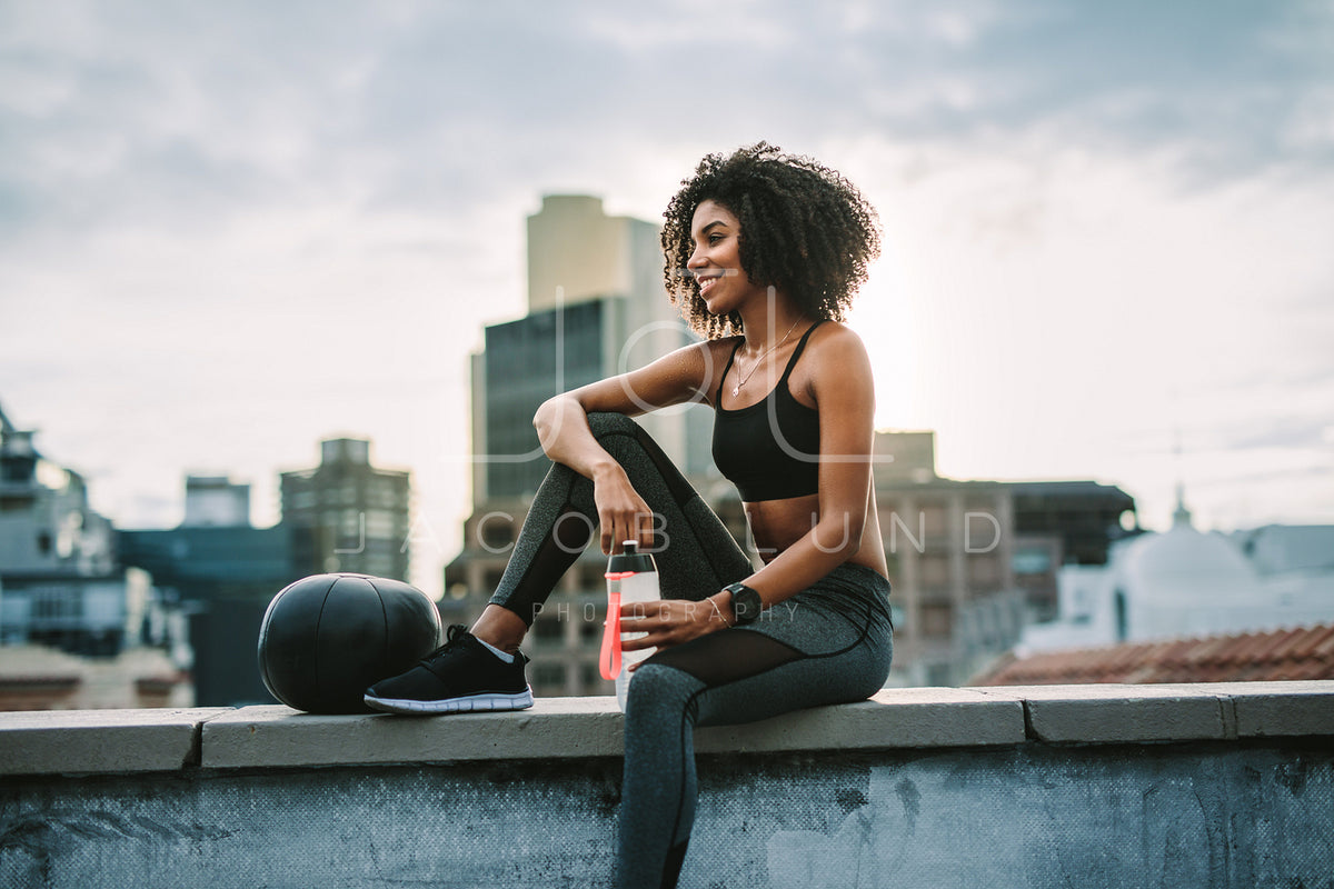 Two women in fitness outfit looking at camera on rooftop after workout  session. Female athletes relaxing after exercising on terrace of building  Stock Photo - Alamy