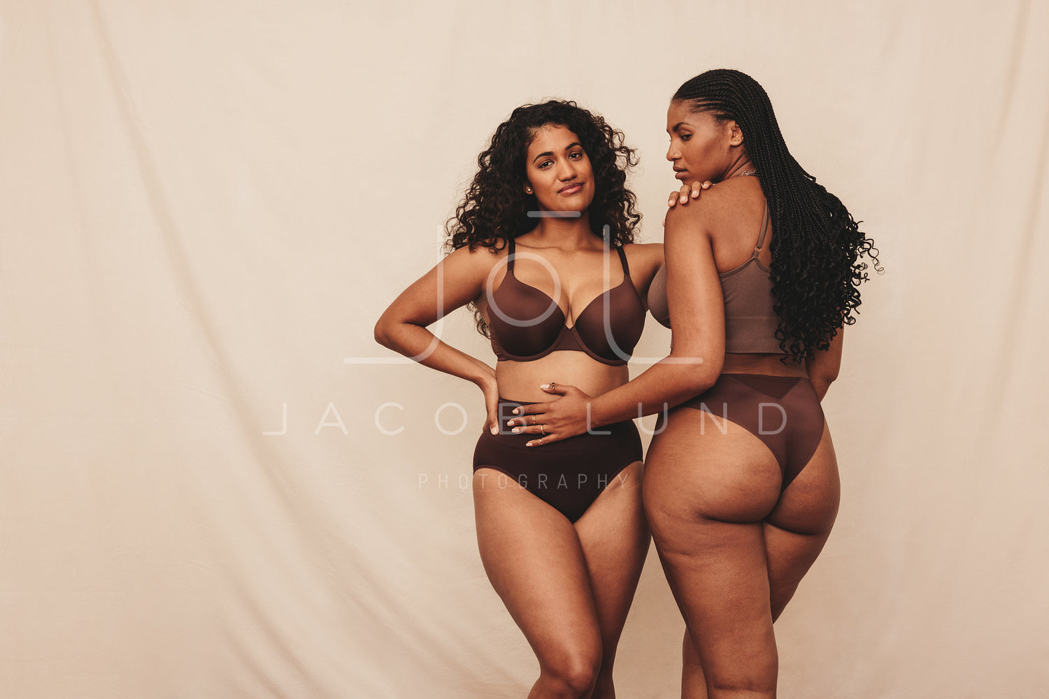 Two young women embracing their natural bodies while wearing brown underwear