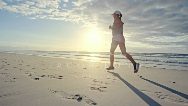 Woman running along the beach in morning – Jacob Lund Photography Store- premium  stock video